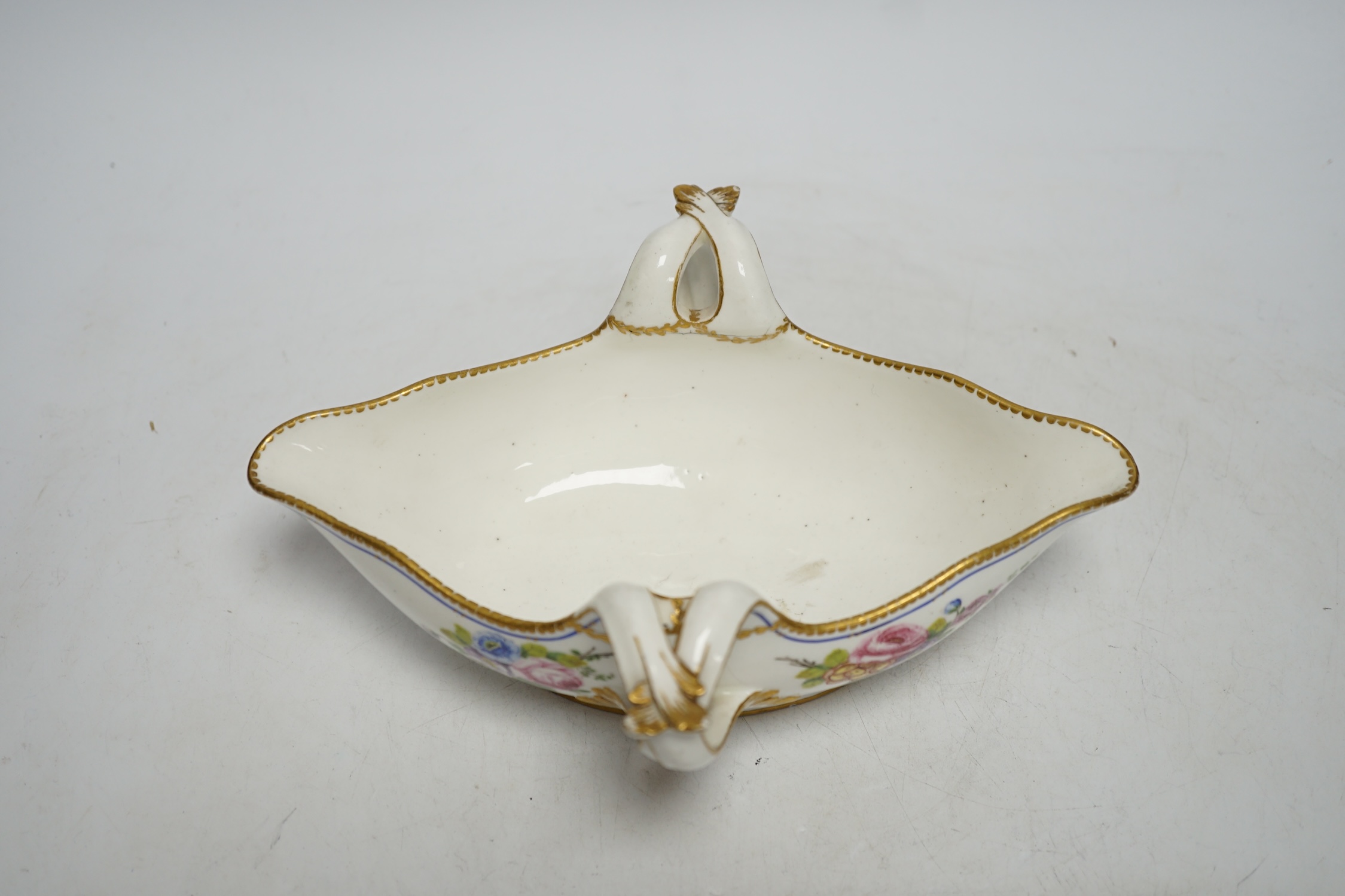 An 18th century Sevres sauceboat, probably later enamelled with flowers, 23.5cm wide